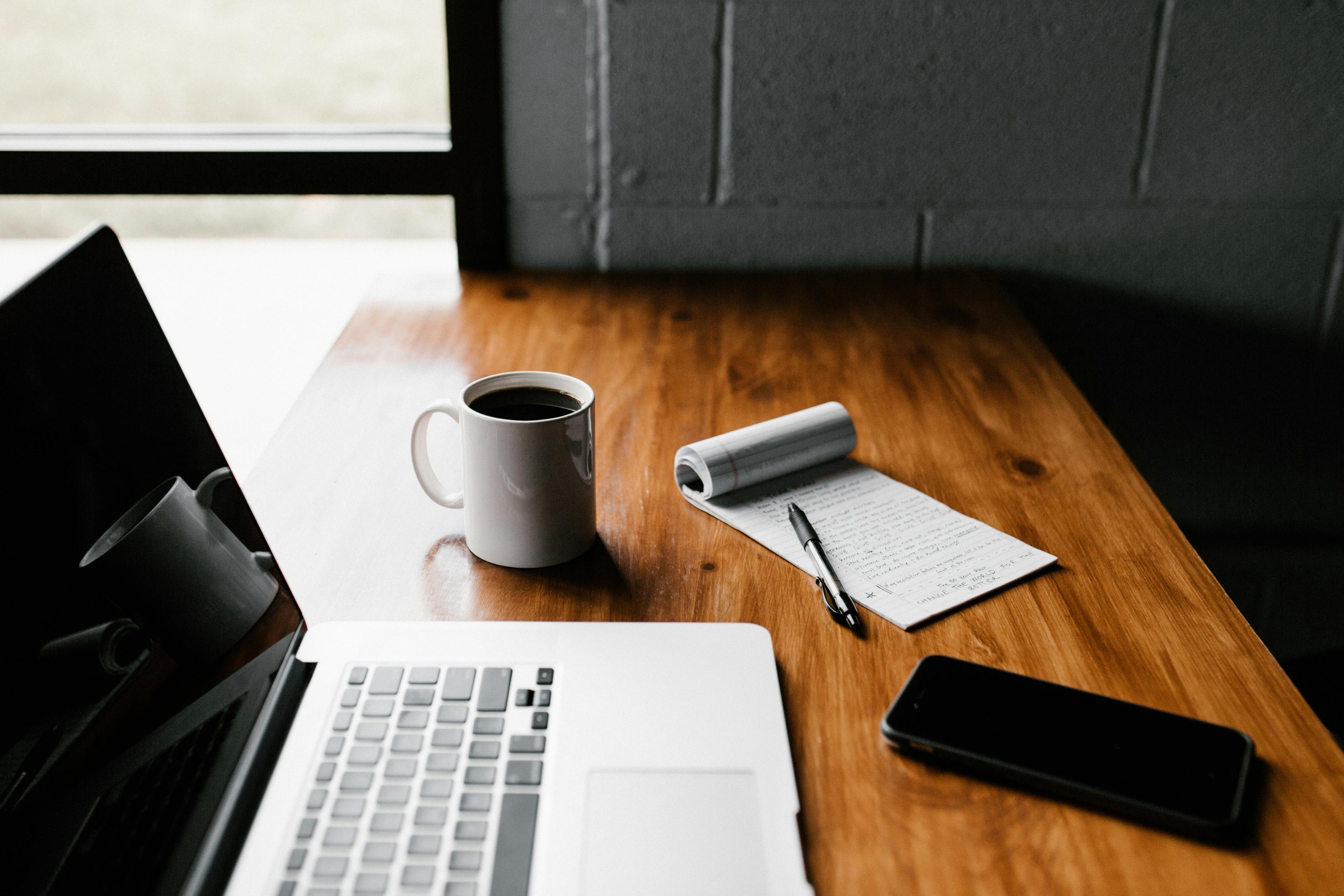 Photo of a notebook and a laptop, courtesy of Unsplash